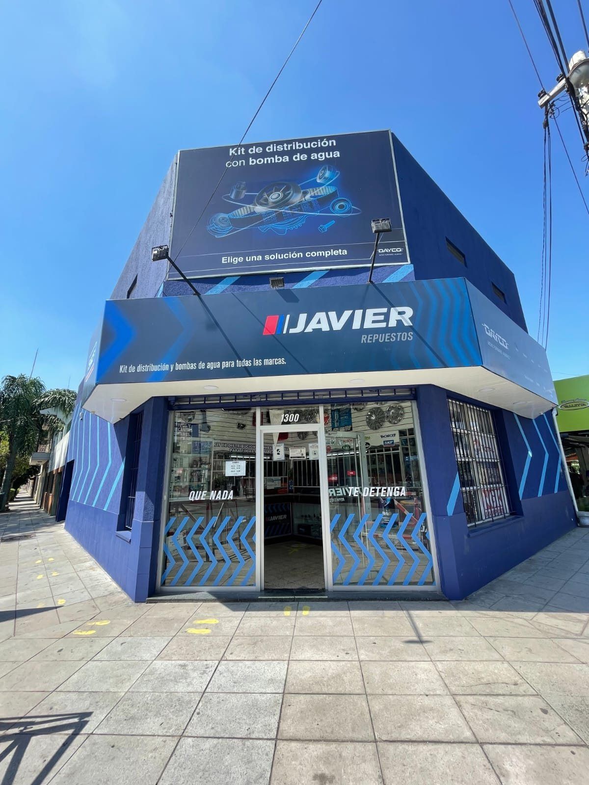 Entrada del local de Repuestos Javier con el cartel de kits de distribución y bombas de agua para todas las marcas