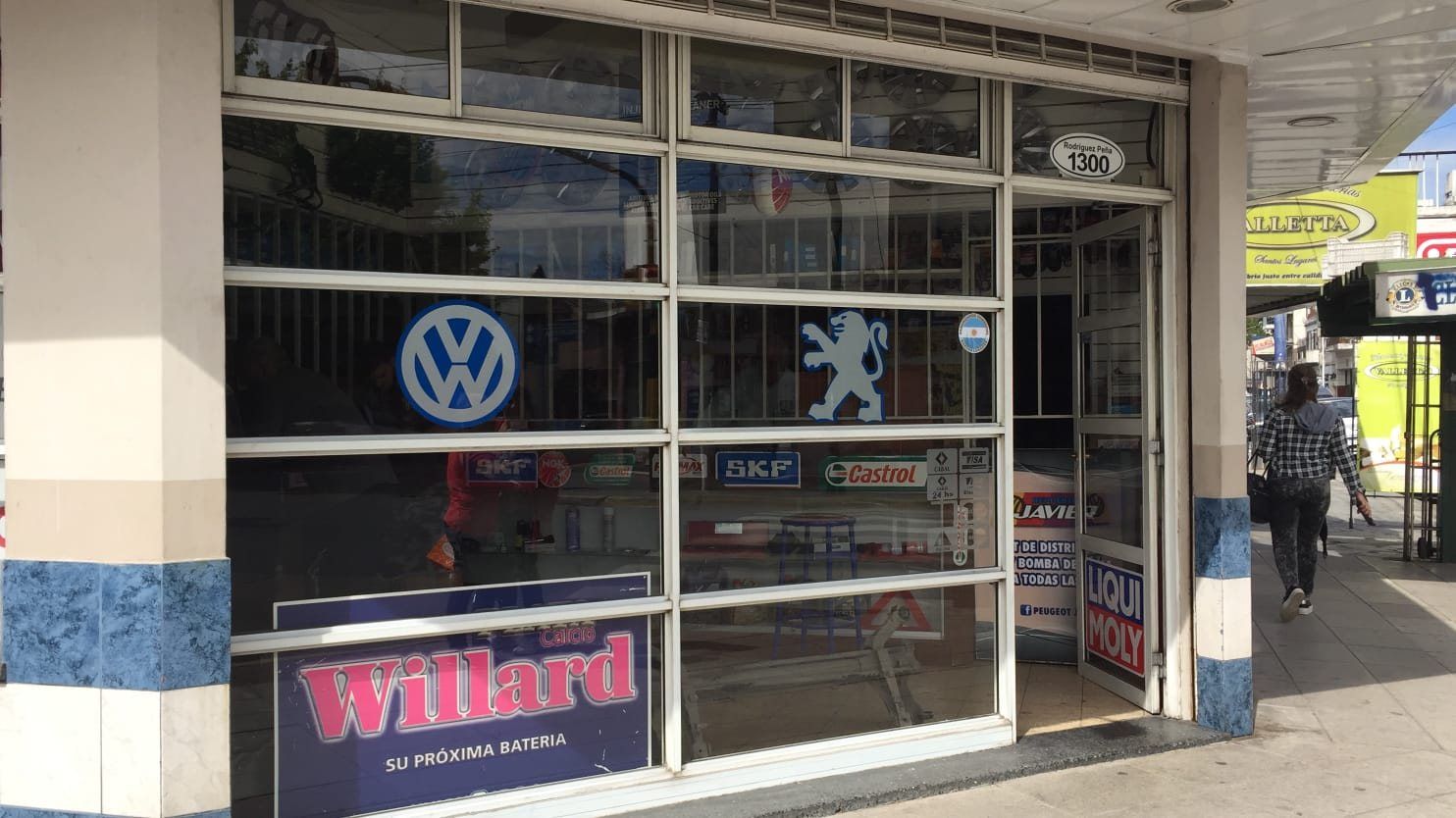 Vidriera de Repuestos Javier con los logos de Volkswagen y Peugeot